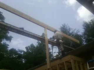 Carpenter setting a ridge beam over a new addition frame — Ice Dam Removal by Roofing Brothers in Boonsboro