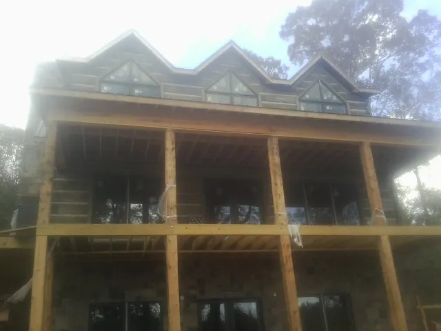 Dormers and porch framing on a large log home under construction — Roof Coating work by our crew in Boonsboro
