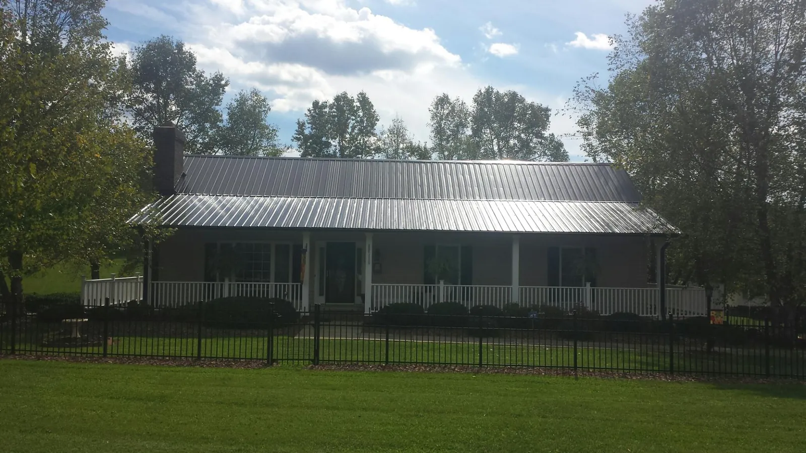 Gray metal roof on a brick ranch with a full width front porch — Gutter Guard Installation work by our crew in Boonsboro