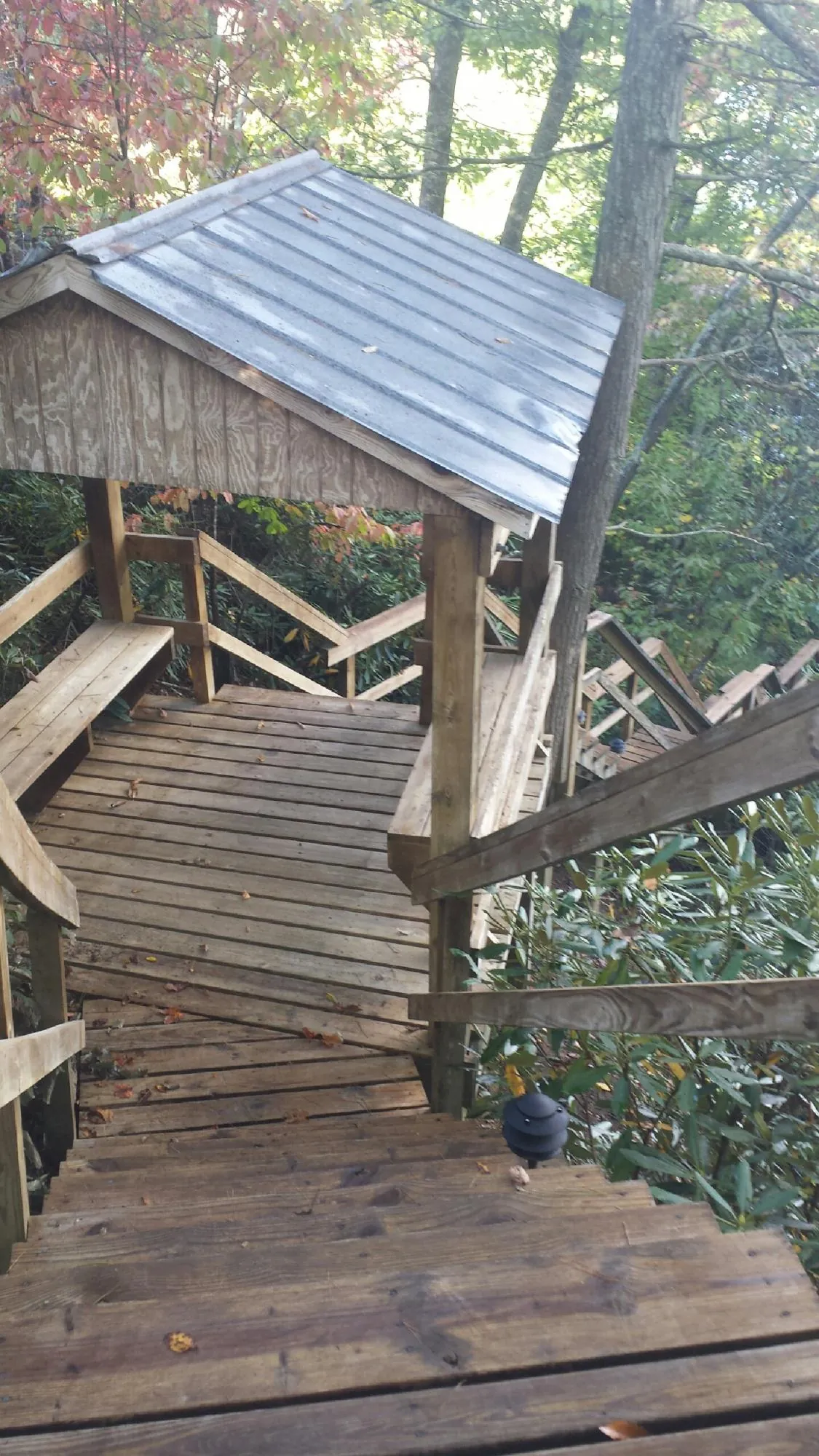 Metal roofed shelter over wooden steps on a wooded walkway — Skylight Repair & Installation work by our crew in Boonsboro